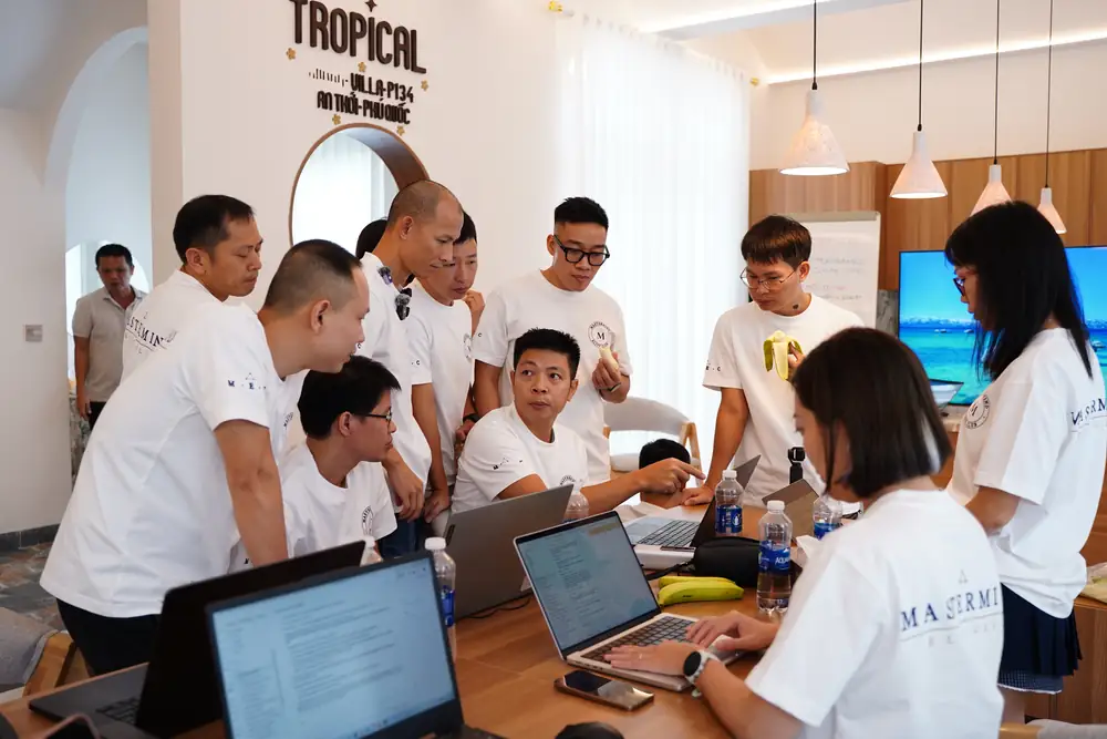 Học viên vây quanh laptop xem một quy trình tự động đang chạy